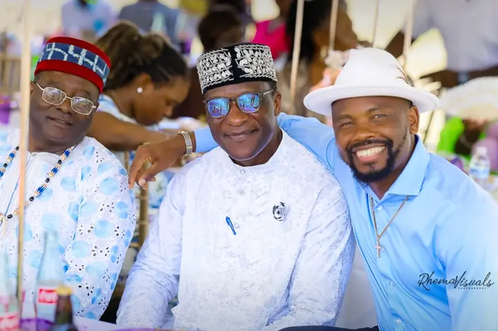 Three members smiling together at a community reception