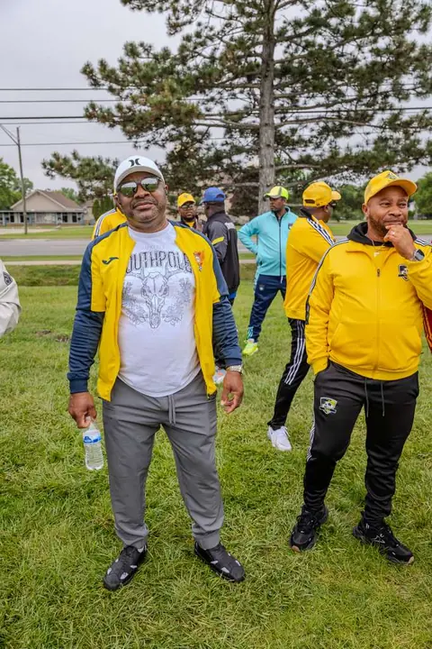 Members in yellow tracksuits at a tournament ground